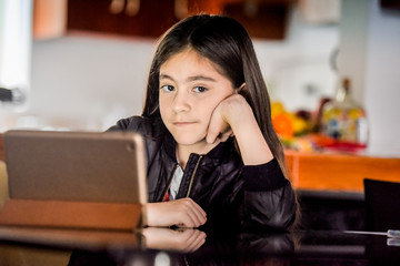 10 years latin girl watching the tablet.