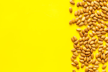 Healthy snack with almonds on yellow background top view mock up