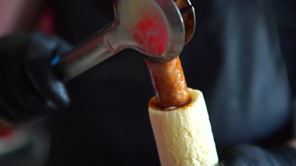 Hotdog - friendly chef preparing fresh ingredients in a fast food snack bar