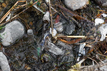 Garbage and plastics on a water course.