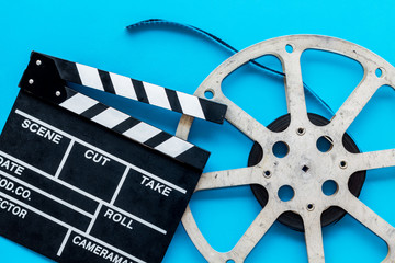 Go to the cinema with film type and clapperboard on blue background top view