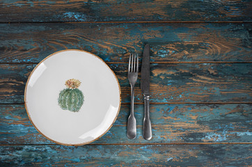 Empty plate with fork and knife on colored wooden background, top view, copy space, mock-up