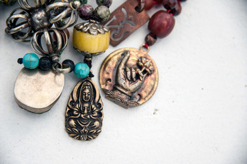 Sacred mala pendants of a buddha and a hand in mudras with a lotus. 