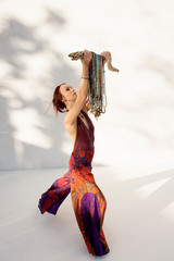 Woman with many yoga mala beads hanging on a cactus bone. 
