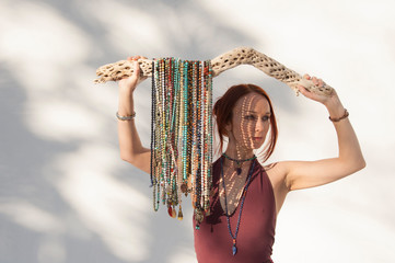 Beautiful woman holding many mala beads hung on a cholla cactus  bone. 