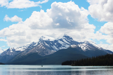 Snow capped mountains rise up from lake on cloudy day
