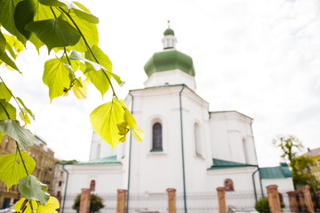 Obraz premium Beautiful orthodox church in Kiev, Ukraine. Old ancient architecture building. White ancient bell tower with green roof in spring time