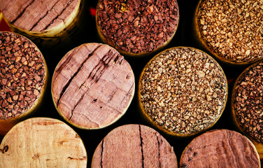 Wine corks side by side in a pile macro close-up background. The used corks display different hues, colours and textures.