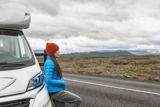 RV Camper Trailer Travel Woman Driving Motorhome Camping Van On Iceland Road Trip. Asian Tourist Driver Taking Break On Adventure Fall Autumn Vacation Looking At Nature Landscape.