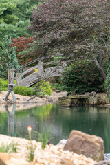 Fototapeta na wymiar Wooden bridge crossing over a small pond portrait