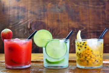 Traditional Brazilian alcoholic cocktail, lemon, strawberry and passion fruit. Caipirinha with sugar syrup and cachaça or vodka. photo for restaurant menu
