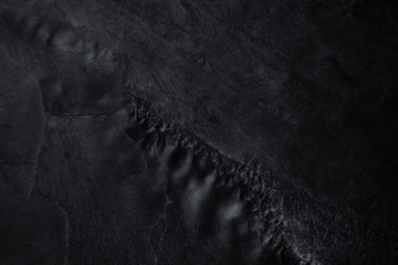 Dark grey black slate background or natural stone texture.