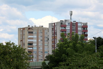 Two old apartment buildings with dilapidated facade and cell phone transmitters and antennas...