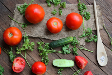 vegetables - tomatoes and cucumbers on a wooden board.