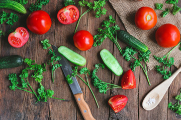 vegetables - tomatoes and cucumbers on a wooden board.