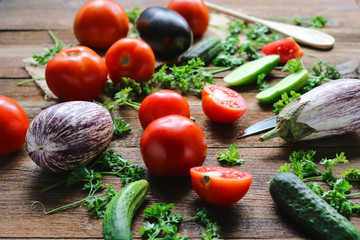 vegetables - tomatoese, eggplants and cucumbers on a wooden board.