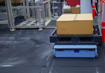 Automated guided vehicle AGV carry cardboard in modern warehouse factory