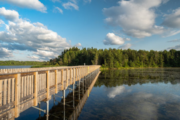 Bridge, clouds, trees reflection with blue sky in the park in Canada