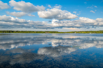 Bridge, clouds, trees reflection with blue sky in the park in Canada