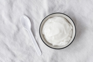 Obraz na płótnie Canvas Natural homemade plain organic yogurt in cup on wood texture background