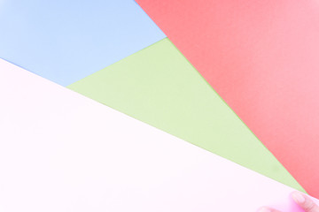 Flat layout of minimal colourful layer of pastel pink, green, blue and red paper background.