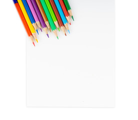 Background of colour pencils at the corner of blank drawing paper for kids study and learn art when back school on isolated background.