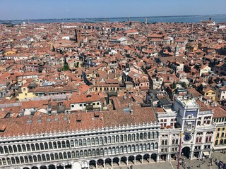 Fototapeta na wymiar A view from the top of St Marks Campanile of St Marks Square looking down on the square with tourists below and the amazing city of Venice on a beautiful sunny summer day.