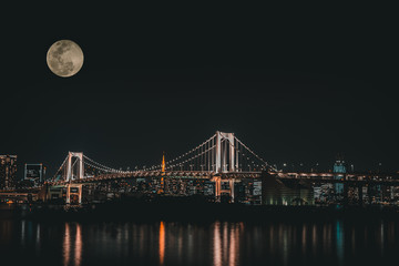 Statue of Liberty with rainbow bridge of Odaiba Tokyo at the moon night with the view of light city...