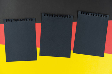 Blacklist Germany. Mourning, ban, sanctions, politics. black sheet of notebook lies on German flag....