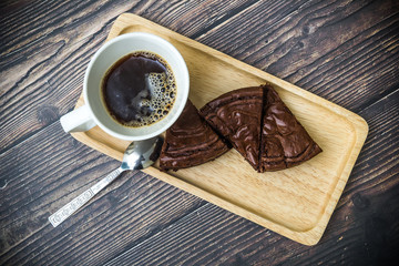Nutella Brownie with americano coffee and coffee bean on the wood table