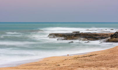 Fototapeta na wymiar Blurred wave motion and empty beach