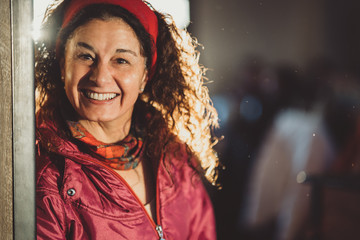 Portrait of a happy mature woman wearing snow outfit and lit from behind