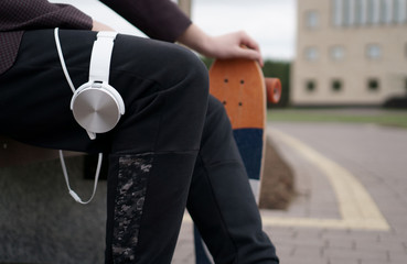the guy is sitting with headphones and skate