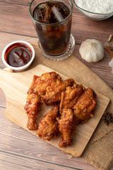 Hot and spicy Korean barbeque fried chicken on wood cutting board