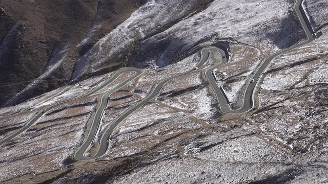 Cars use winding zigzag road to reach Ganden monastery, in cold Winter conditions on Tibetan plateau