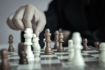 Close up shot hand of business woman playing the chess board to win by killing the king of opponent metaphor business competition winner and loser select focus shallow depth of field with vintage tone