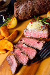rustic medium butter beef steak with herbs and potato wedges