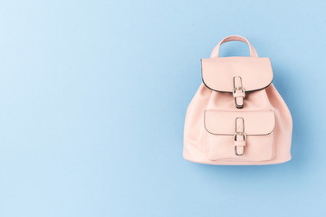 Overhead view of pink backpack on blue background