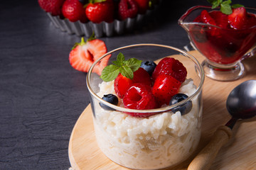 delicious milk rice with different berries and red fruit jelly