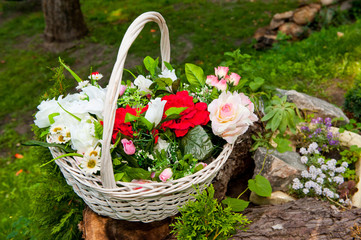 White wicker basket with bright artificial flowers