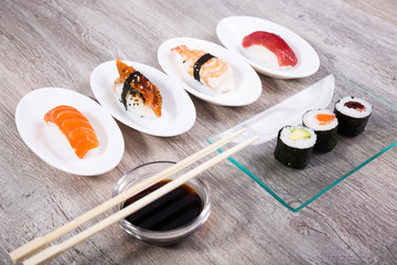 Fototapeta na wymiar four kinds of Nigirisushi on oval saucers and makizushi