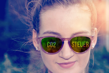 Eine Frau mit Sonnenbrille und Co2 Steuer