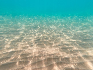 underwater background with sandy sea bottom. Beautiful texture of the sea and ocean water. Pure water texture.
