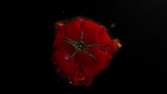 Crush The Raw Tomato With Leaves On A Black Background
