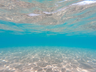 underwater background with sandy sea bottom. Beautiful texture of the sea and ocean water. Pure water texture.