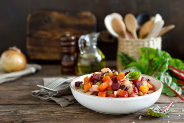 Beetroot or beet salad with boiled vegetables on wooden rustic table closeup