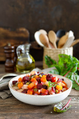 Beetroot or beet salad with boiled vegetables on wooden rustic table closeup