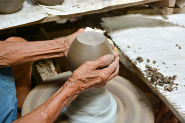 The old man is making pottery.