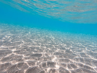 underwater background with sandy sea bottom. Beautiful texture of the sea and ocean water. Pure water texture.