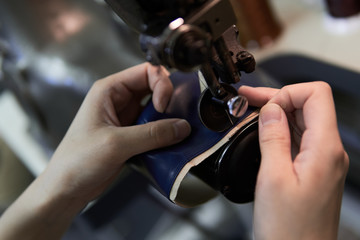 ミシンで革を縫う女性の手元 - obrazy, fototapety, plakaty